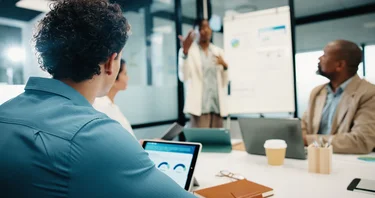 Team diskutiert Datenanalysen und Kennzahlen während einer Präsentation.
