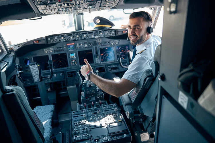 Porträtansicht eines Piloten mit Kopfhörern, der im Cockpit eines Zivilflugzeugs sitzt